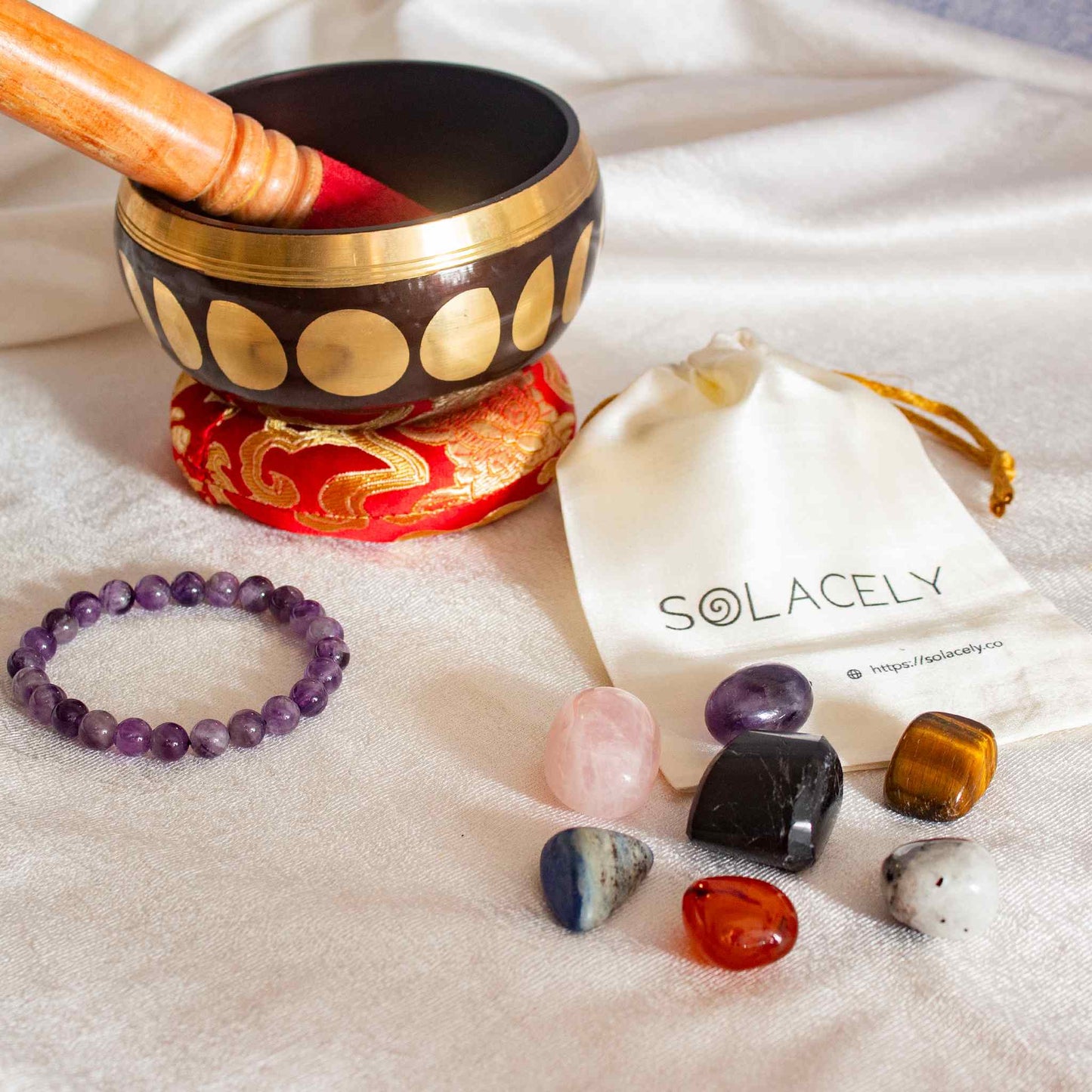 meditation with singing bowl, amethyst bracelet, tumble stone and sage